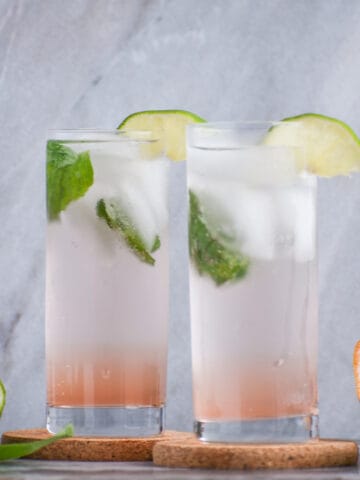 grapefruit vodka soda in a collins glass with lime and basil garnishes