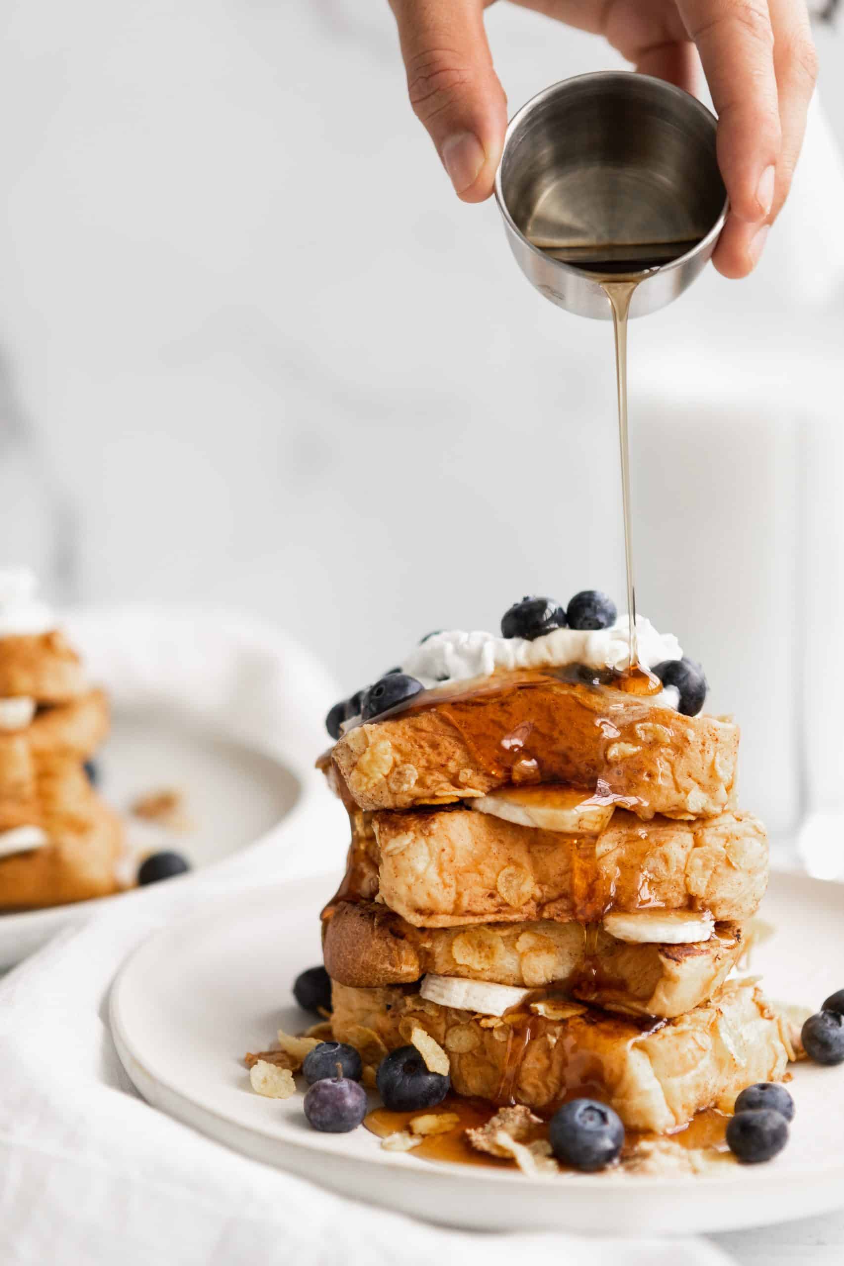 Vegan Cornflake French Toast with bluebrries and vegan agave syrup drizzled on top.