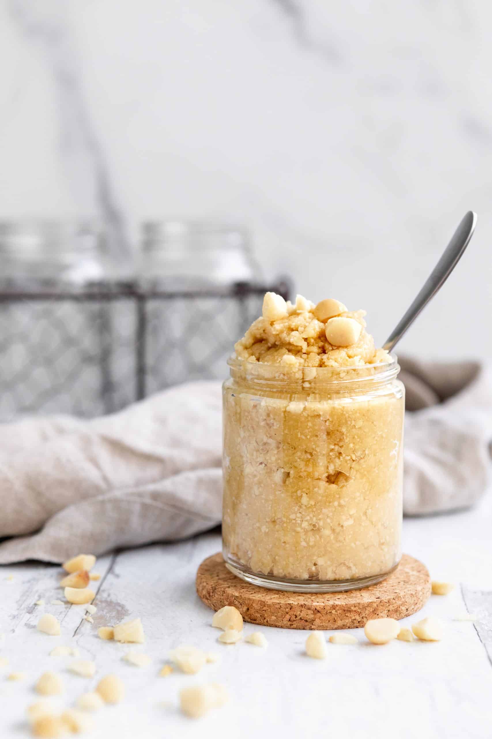 Macadamia Nut Butter in a jar, topped with macadamias.