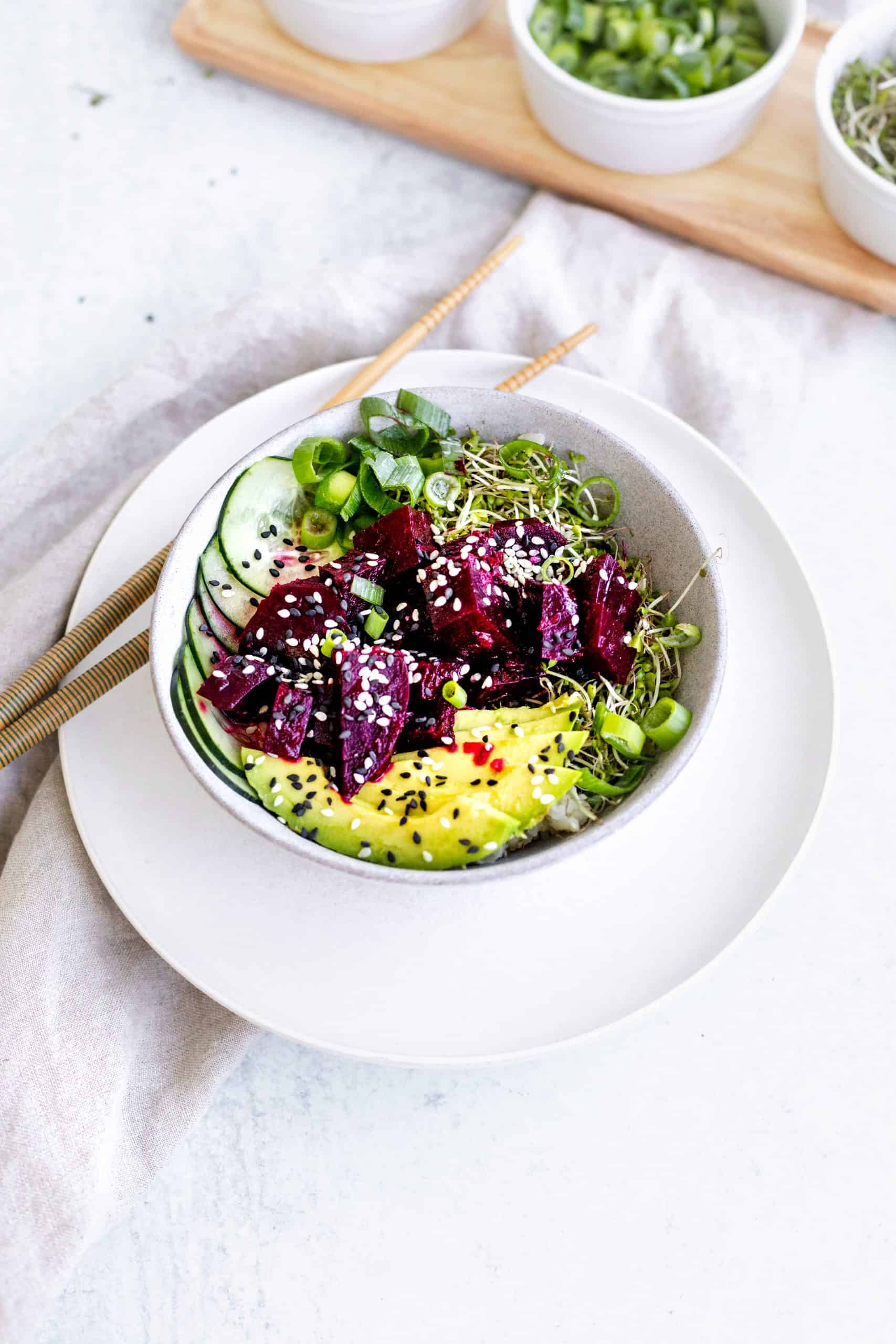 Vegan Beet Poke Bowl with sides or rice, scallions, and sprouts.