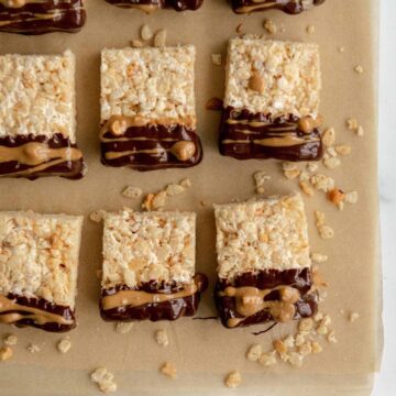 Vegan Rice Krispie Treats with Chocolate and Peanut butter drizzled on them.