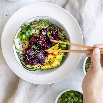 Vegan Beet Poke Bowl with beets, avocado, scallions, sprouts and cucumber.