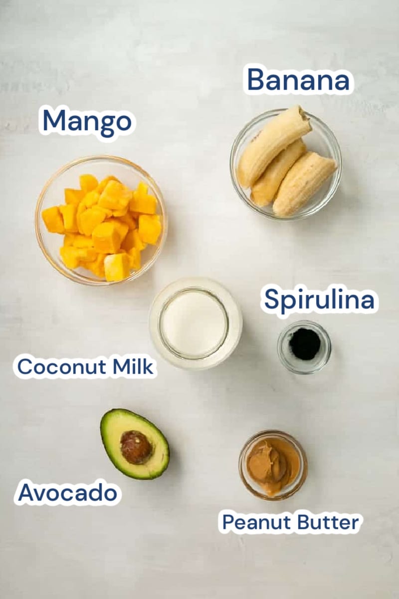 ingredients for spirulina smoothie: mangoes, bananas, spirulina, coconut milk, peanut butter, avocado.