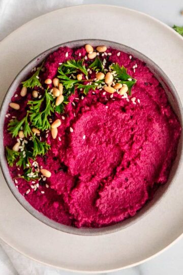 bright pink lemon beet hummus with parsley, pine nuts and sesame seeds.