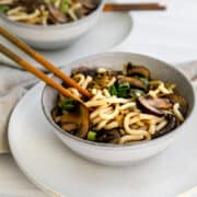 mushroom udon noodles in a bowl with chopsticks