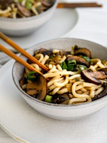 mushroom udon noodles in a bowl with chopsticks