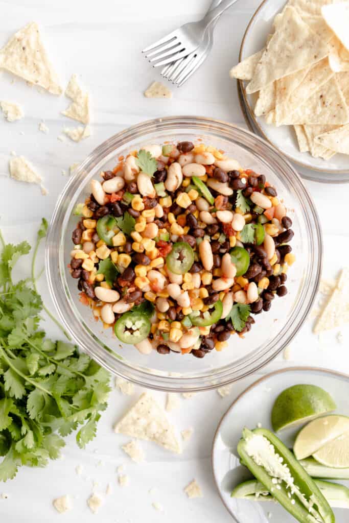 Bean Salad overhead with cilantro, limes, jalapenos, and tortilla chips. 