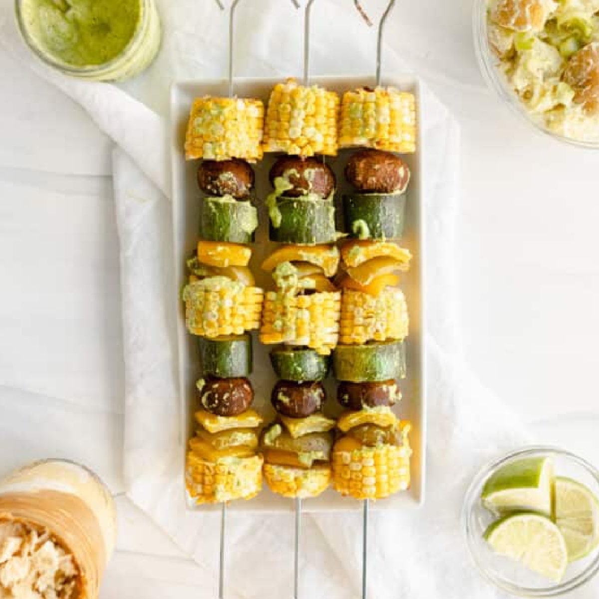 Grilled Veggie Kebabs overhead - corn, zucchini, mushrooms, and bell peppers on a metal skewer.