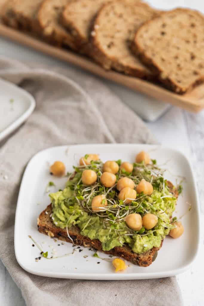 avocado toast with chickpeas and sprouts on a plate