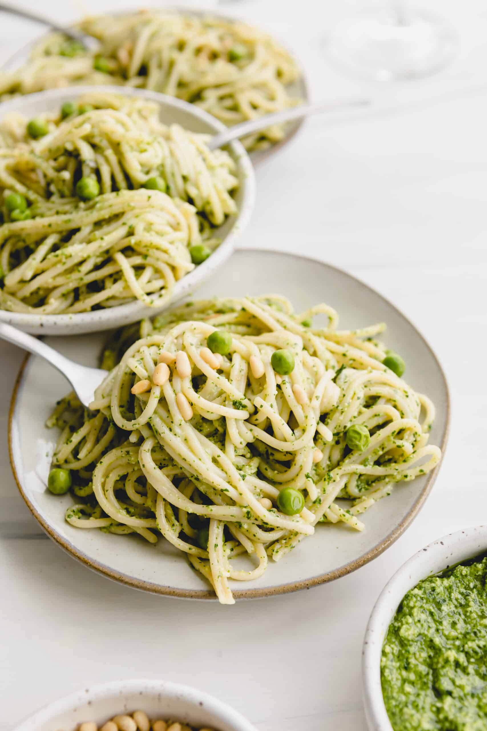Pesto pasta topped with peas and pine nuts