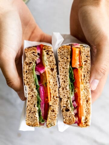 Roasted carrot sandwich in hands