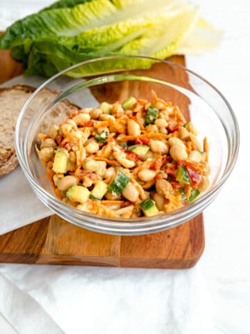 Vegan Chickpea Salad in a glass bowl with bread and lettuce