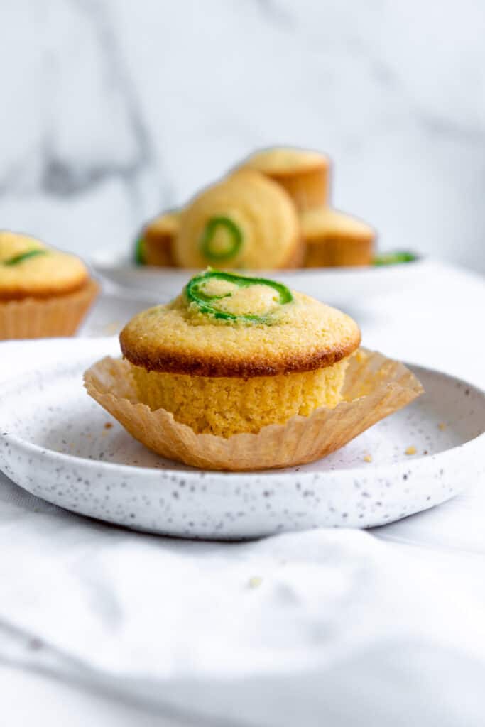 easy vegan cornbread muffins on a plate with the wrapper halfway off