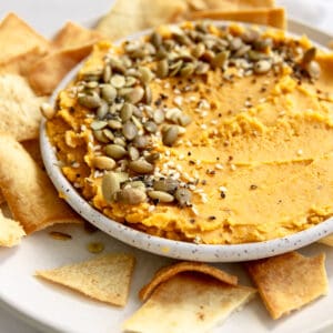 butternut squash hummus with pita chips, pumpkin seeds and sesame seeds.