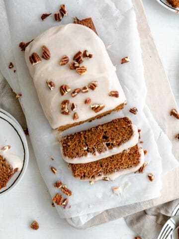 carrot cake loaf slices, topped with cream cheese icing and chopped pecans
