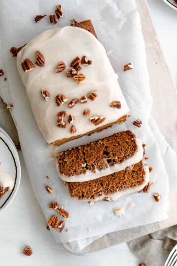 carrot cake loaf slices, topped with cream cheese icing and chopped pecans.