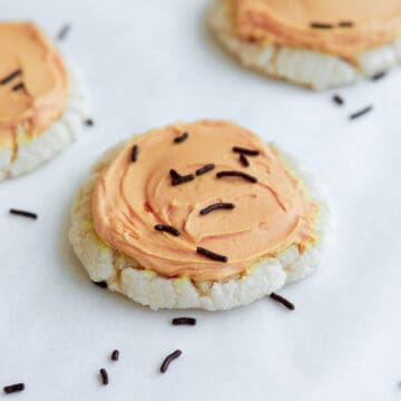 soft vegan sugar cookie with orange icing and sprinkles.