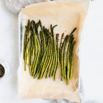 crispy roasted asparagus on a sheet tray with parchment paper