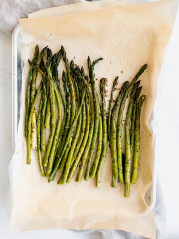 crispy roasted asparagus on a sheet tray with parchment paper