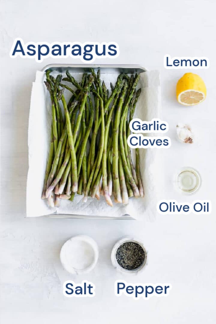 baked asparagus ingredients, lemon, asparagus, garlic cloves, olive oil salt and pepper. 