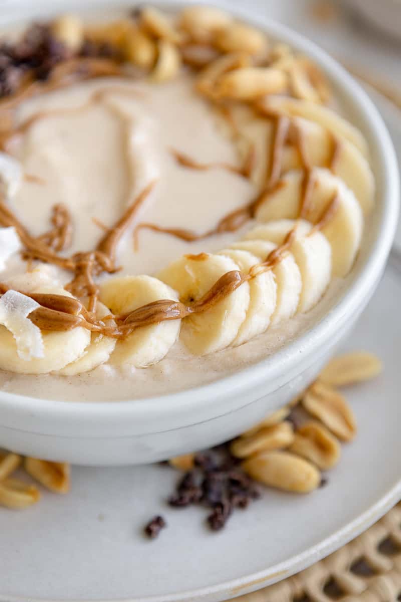 Peanut butter and banana smoothie topped with banana slices and peanut butter drizzle
