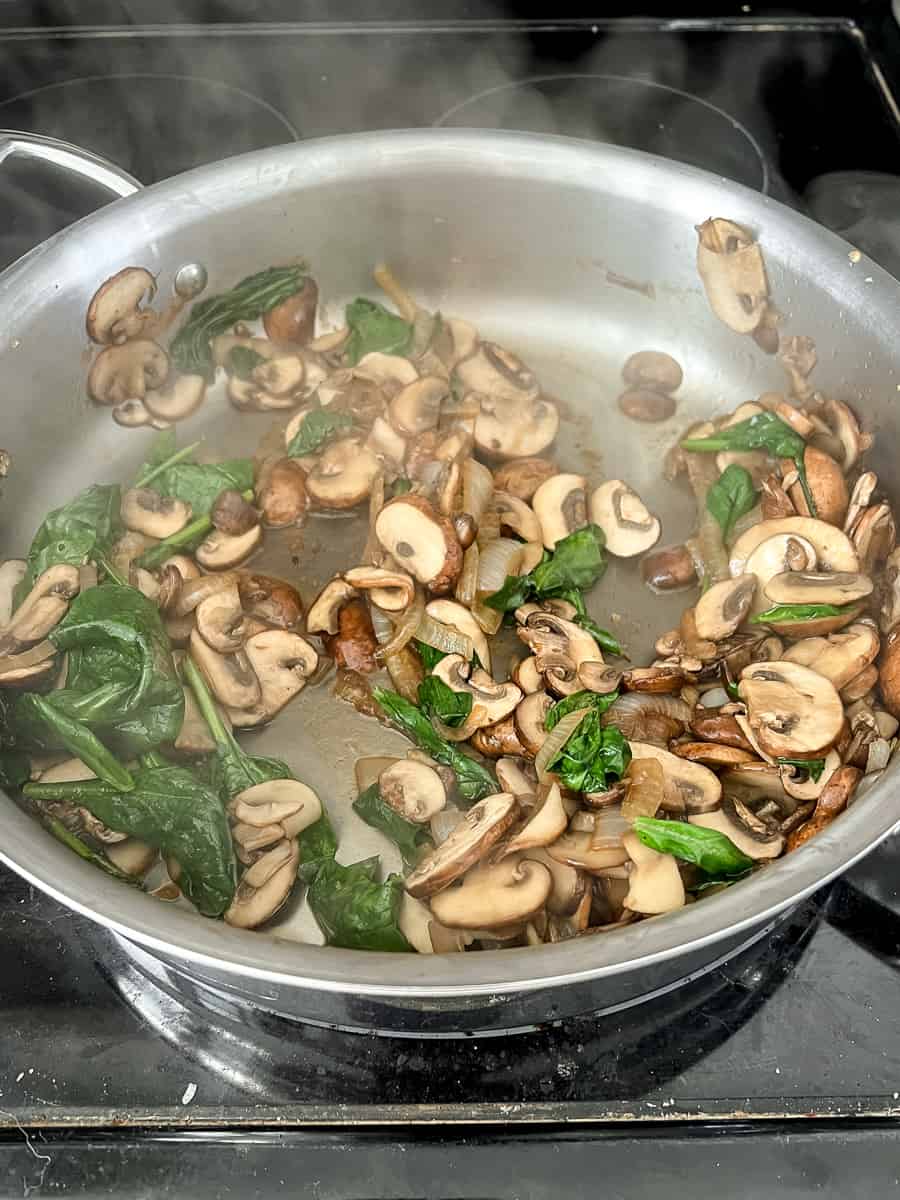 Cooked mushrooms and wilted spinach for the filling