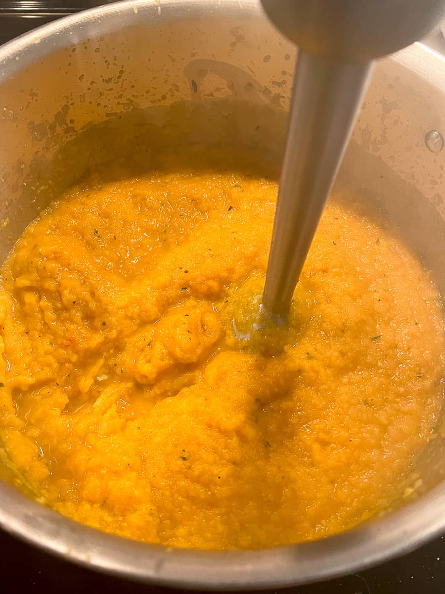 Early stages of blending butternut squash bisque with immersion blender - still a little chunky