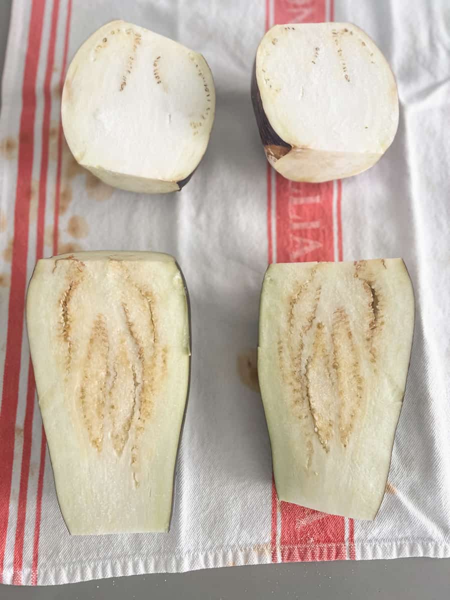 Eggplant cut side up with salt. Little droplets of water escaping. 
