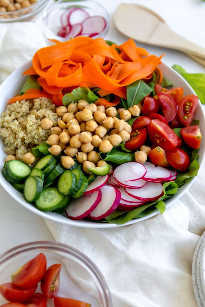 rainbow salad - carrot ribbons, quinoa, chickpeas, sliced cucumbers and radishes, tomatoes and greens