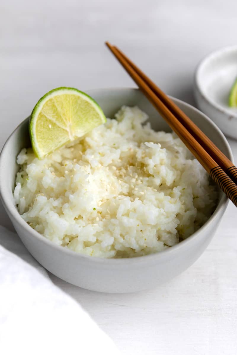 coconut rice with sesame seeds, garnished with a lime