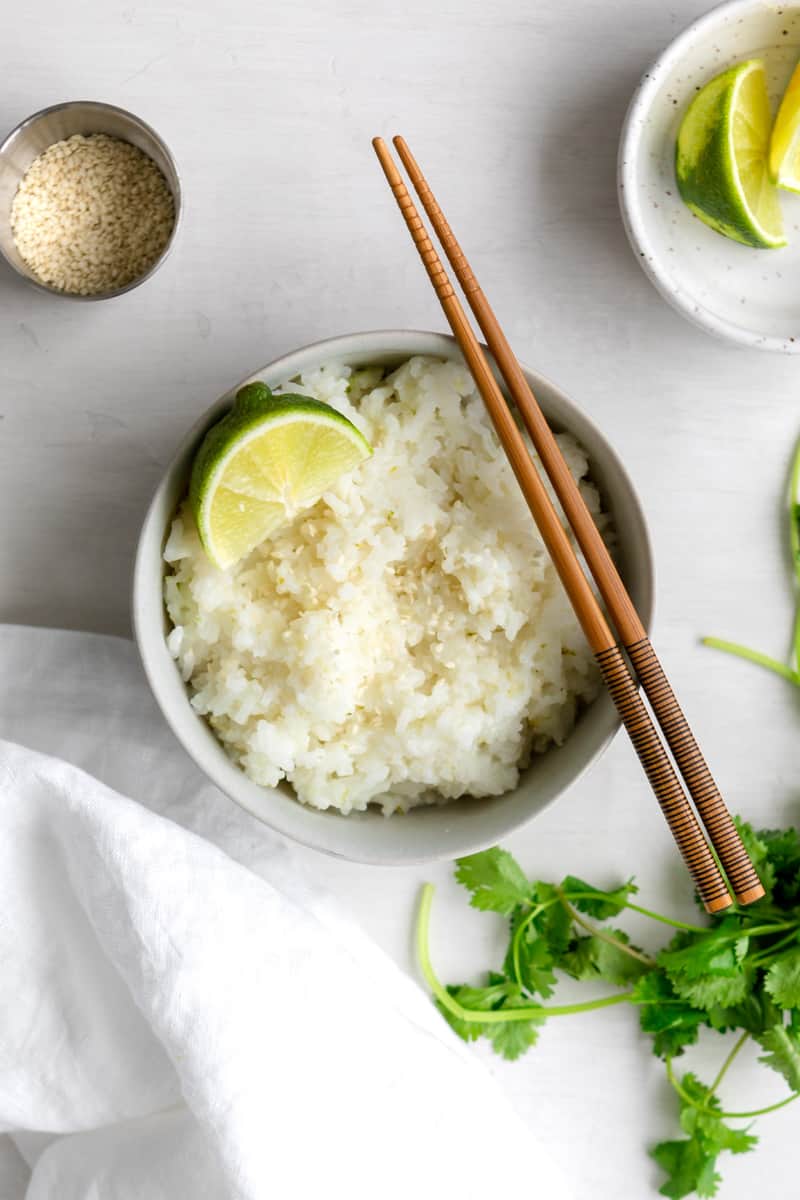 Bowl of coconut lime rice with sesame seeds, and chopsticks