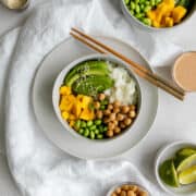 chickpea buddha bowl with mango, avocado, rice, edamame and chopsticks