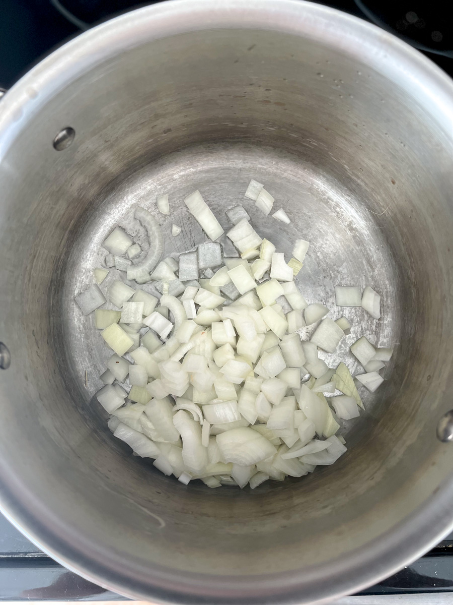 Diced onions sauteeing in a medium saucepan