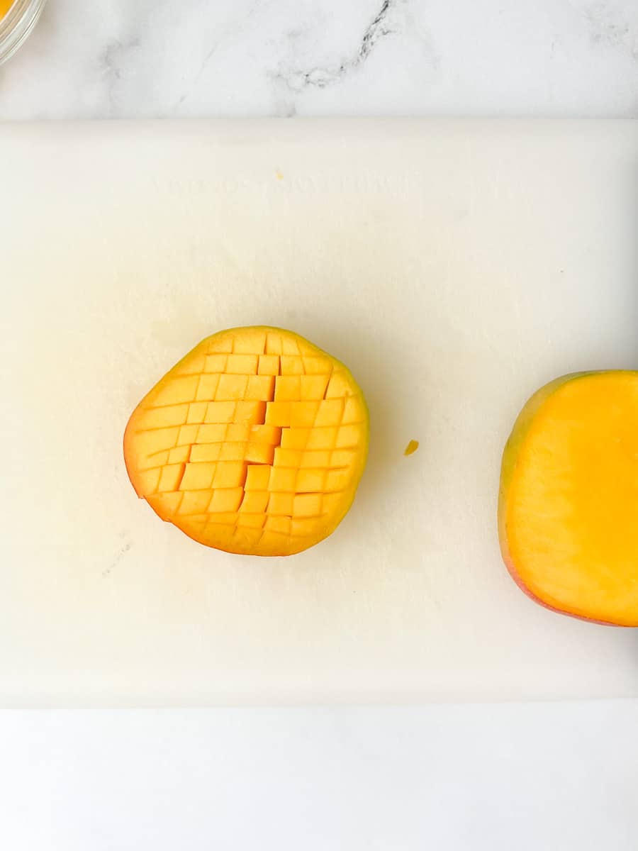 mango third with grid sliced into mango flesh, without piercing skin