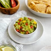 mango guacamole in a bowl with tomatoes