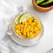 mexican street corn off the cob in a bowl garnished with lime