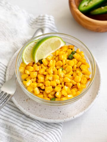 mexican street corn off the cob in a bowl garnished with lime