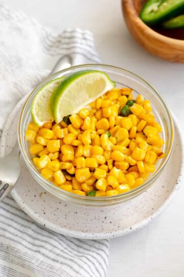 mexican street corn off the cob in a bowl garnished with lime.