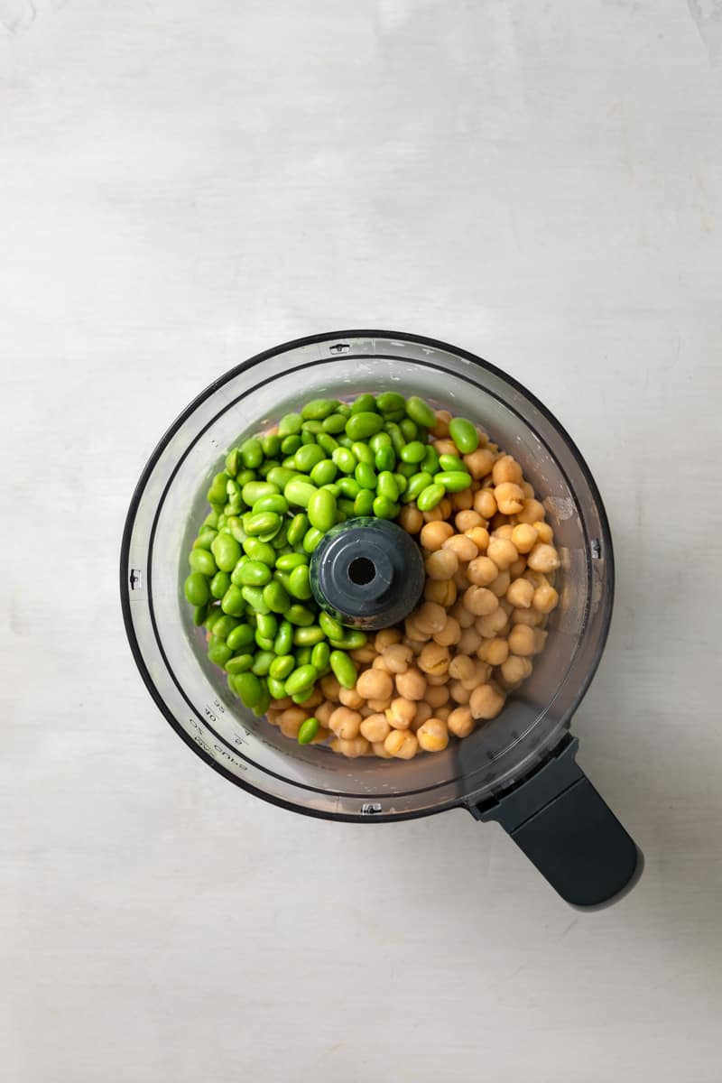 food processor overhead filled with chickpeas and edamame beans