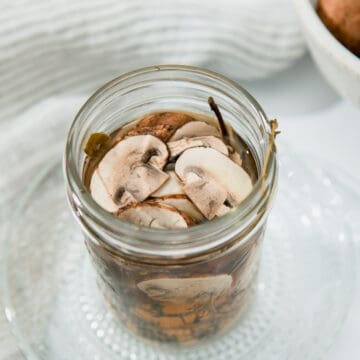 Quick Pickled Mushrooms in a mason jar filled with brine.