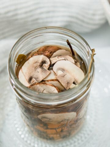 pickled mushrooms in a mason jar filled with brine