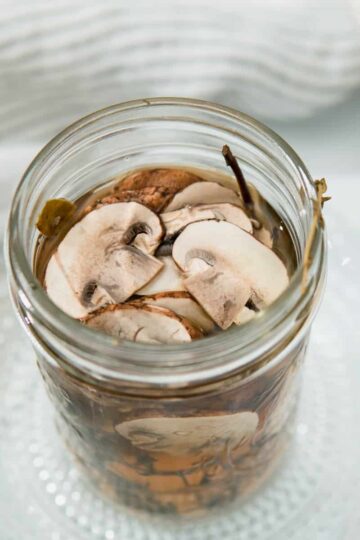 Quick Pickled Mushrooms in a mason jar filled with brine.