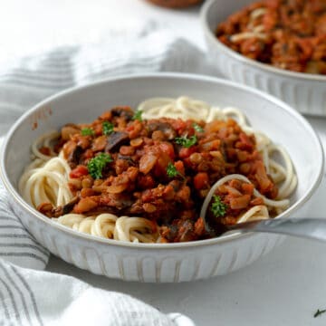 Vegan Spaghetti Bolognese with lentils and parsley leaves.