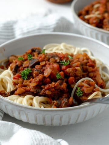 spaghetti bolognese with lentils and parsley leaves