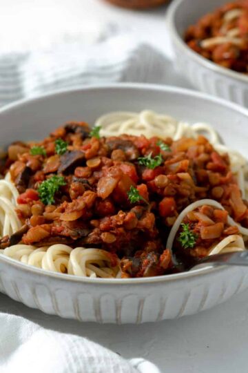 Vegan Spaghetti Bolognese with lentils and parsley leaves.