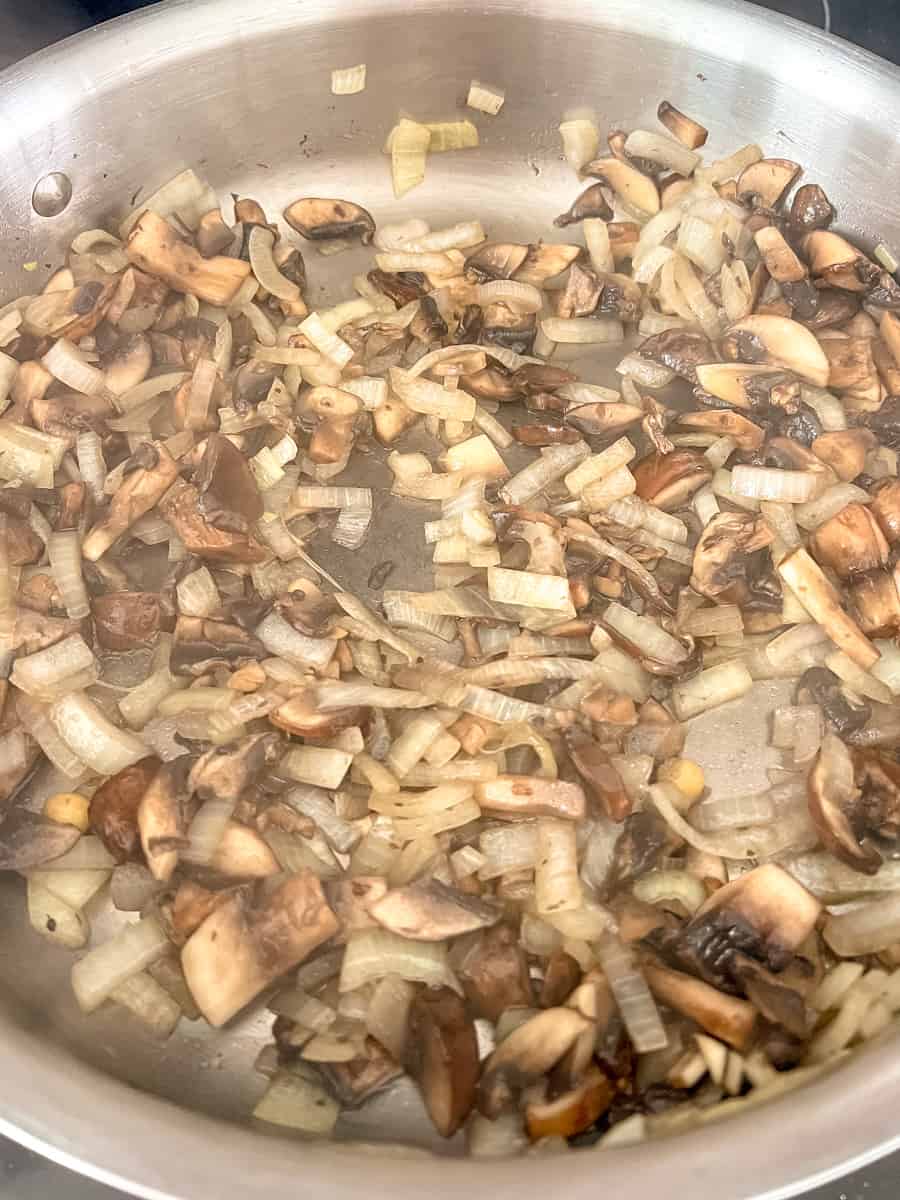 sauted mushrooms and onions in a frying pan - mushrooms have shrunk to about half their size raw. 