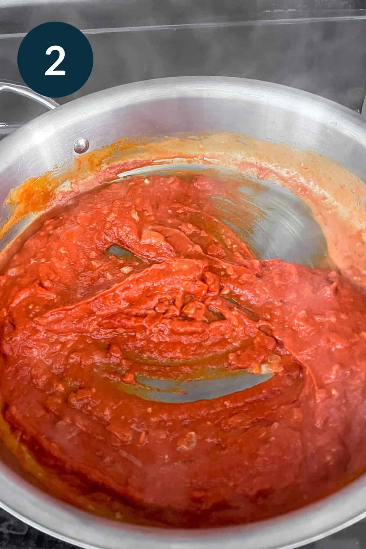 thick tomato paste and coconut cream sauce combining with shallot and garlic mixture.