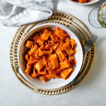 rigatoni covered in red vodka sauce in a bowl with a fork.