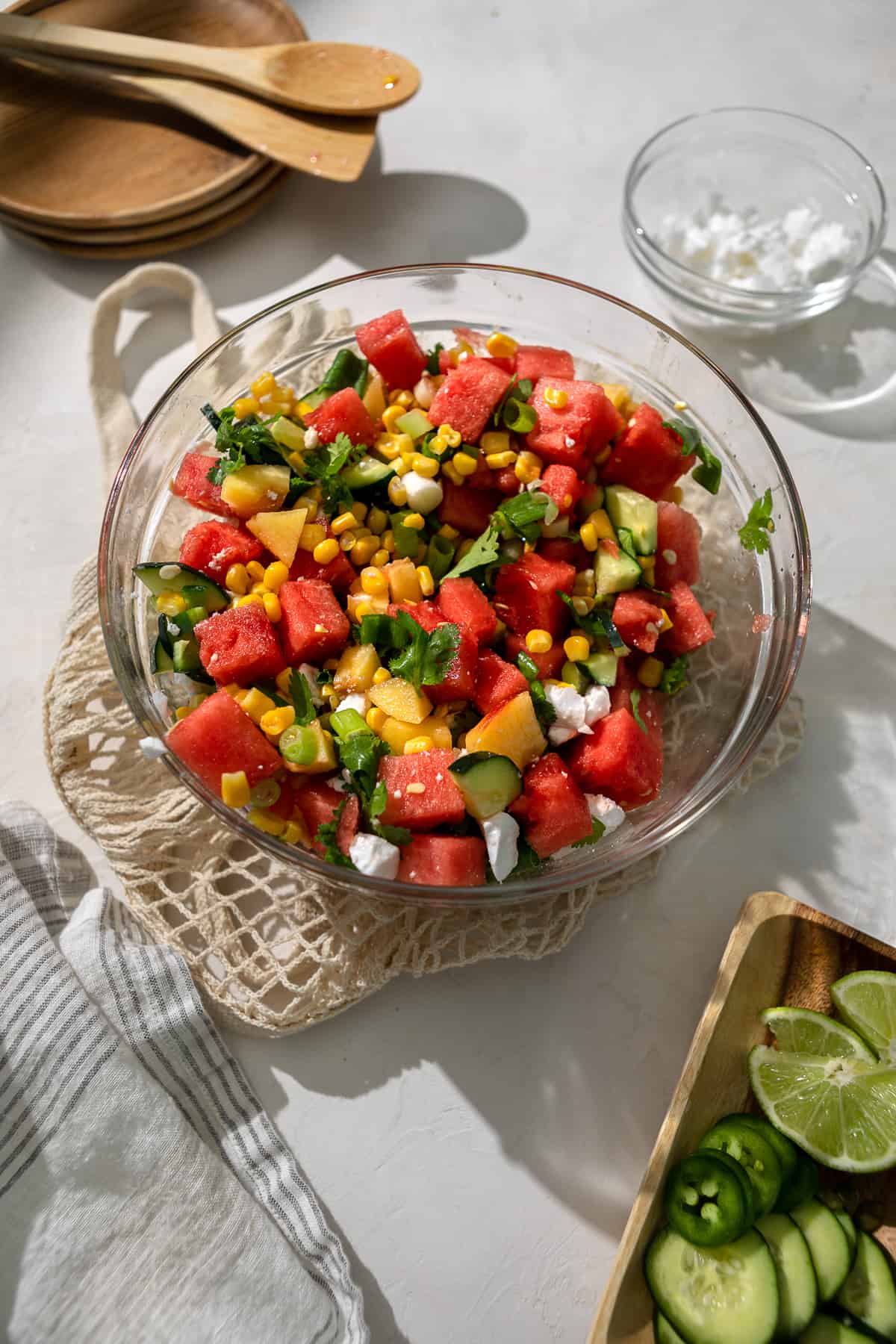 Summer watermelon salad with peaches and corn and limes in the corner.