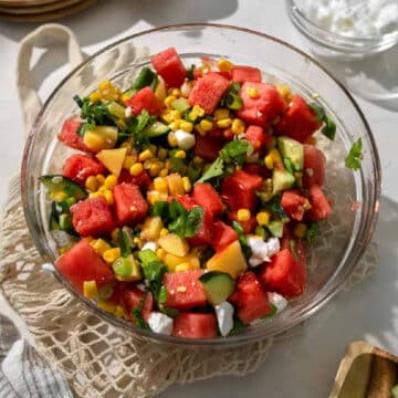 watermelon peach salad in a clear bowl.